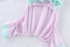 Primo piano dettagliato di abiti rinfrescanti per animali in rete rosa con finiture menta.