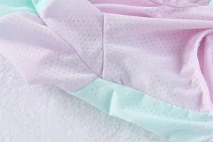 Vista dettagliata della camicia rinfrescante per animali in mesh traspirante rosa e verde menta.