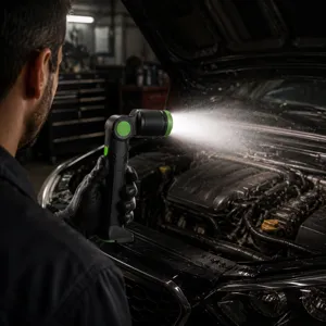 In-use detail shot of foldable LED work light illuminating car engine bay in garage workshop.