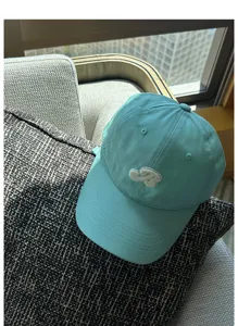 Detailed shot of the mint green baseball cap with cute embroidered patch and curved brim.