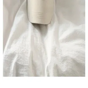 Close-up detail of a white baseball cap on rumpled fabric, minimalist style, spring.