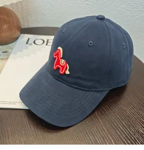 Primo piano di un berretto da baseball blu scuro con un ricamo di cavallo rosso.