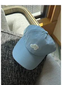 Close-up shot of the light blue baseball cap featuring delicate white embroidery details.