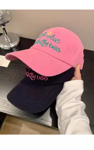 Detailed view of casual embroidered baseball caps in pink and navy blue with soft top design.