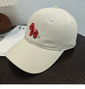 Cappellino da baseball beige con cavallo ricamato rosso, elegante e protettivo dal sole estivo.