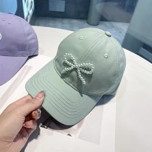 Mint green baseball cap for women featuring an elegant pearl bow design, sun protection and stylish.