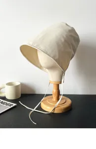 Dettaglio cappello da sole beige, tessuto ad asciugatura rapida con lunghi laccetti.