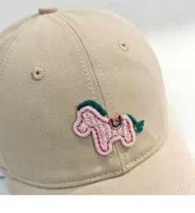 Primo piano dettagliato di un berretto da baseball beige con un grazioso pony ricamato.