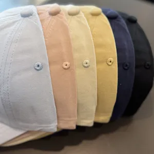 Close-up detail view of colorful casual baseball caps arranged in a neat gradient row.