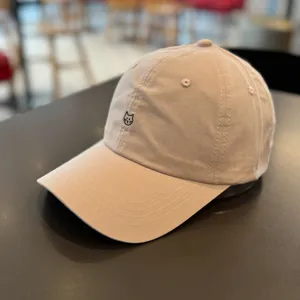 Close-up of beige baseball cap with cute cat embroidery, showing detailed stitching texture.