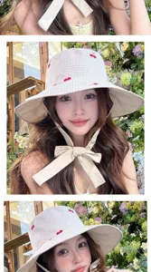 Gros plan détaillé du chapeau bob à carreaux doux avec jolie broderie de cerises et de liens.
