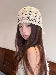 Detail view of a women's beige crochet hollow lace headscarf hat with artistic retro style.