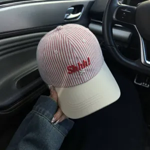 Stylish striped embroidered baseball cap with curved brim and unique red letter details.