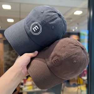 Detailansicht von lässigen weichen Baseballcaps in Grau und Braun mit edler Stickerei.