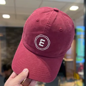 Burgunderrote weiche Baseballkappe mit weißem gestickten Buchstabenlogo, lässiger Sonnenschutz.