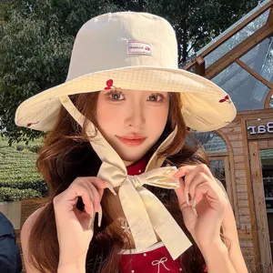 Chapeau de soleil bob femme été avec bord à carreaux jaunes et broderie de cerises.