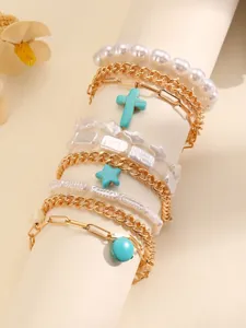 Close-up details of multi-layer boho bracelet set featuring turquoise cross and star charms.