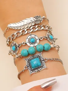 Close-up detail of multi-layer boho bracelet set with turquoise stones and feather charm.
