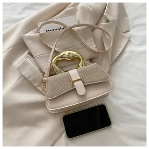 Beige women shoulder bag with metallic handle and elegant glitter flap detail.