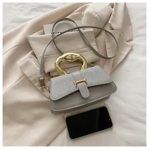 Grey shoulder crossbody bag with unique gold handle and elegant flap design for daily wear.