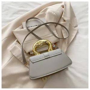 Chic grey crossbody shoulder bag featuring a unique gold curved handle and sparkling flap design.