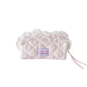 Pink quilted cosmetic bag with cute lace ruffles and bow zipper for daily makeup storage.