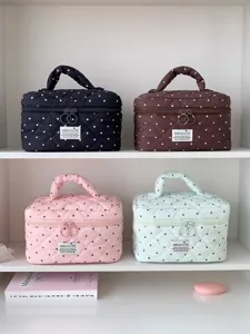 Borsa cosmetica trapuntata con pois carini, manico portatile e ampio spazio per il trucco quotidiano.
