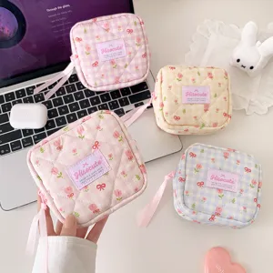 Detailed view of quilted cosmetic bag with cute tulip print, plaid pattern and bow ribbon.