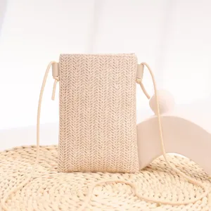 Vue détaillée du mini sac à bandoulière tressé beige élégant pour téléphone, idéal en été.