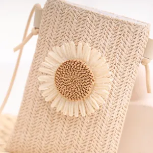 Détail en gros plan du mini sac bandoulière en paille tissée avec une belle fleur