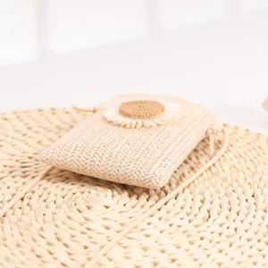 Gros plan sur le sac de téléphone mini tressé en paille d'été, joli décor de fleurs, sac.