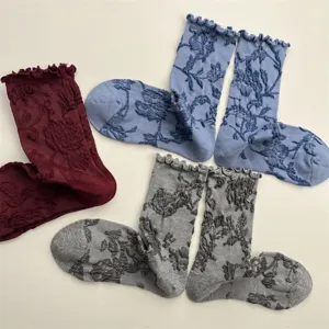 Detail view of vintage style women socks featuring delicate ruffle cuffs and embossed floral patterns.