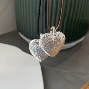 Closeup view of trendy hammered textured heart pendant necklace with beaded details, elegant design.