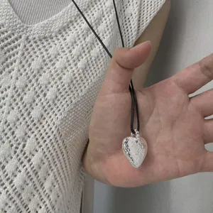 Hammered silver heart pendant necklace with black cord, sweet cool style jewelry detail.