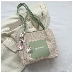 Large capacity woven straw tote bag with green shoulder strap and front pocket for women.