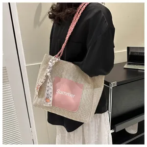 Straw woven tote bag detail showing pink front pocket with Summer print and stylish patterned scarf.