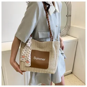 Woven straw tote bag for women, stylish summer shoulder bag with leather pocket and scarf.