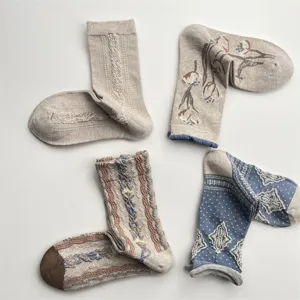 Detailed view of vintage style mid-calf socks featuring cute tulip prints and cable knit textures.