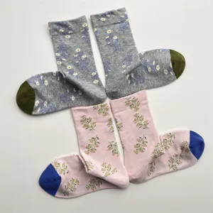 Close-up detail of vintage floral cotton mid-calf socks with contrast toes and cute print.