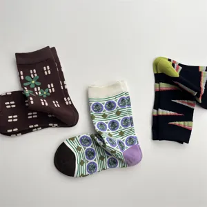 Detailed view of fashionable cotton mid-tube socks with floral and geometric patterns.
