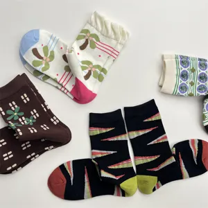 Detailed view of colorful cotton socks featuring cute palm trees, flowers, and geometric patterns.