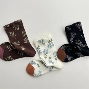 Close-up detail of retro floral cotton mid-tube socks featuring contrast toe and heel.
