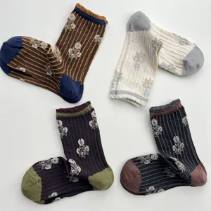 Detailed view of vintage women's mid-calf socks with vertical stripes and floral relief patterns.