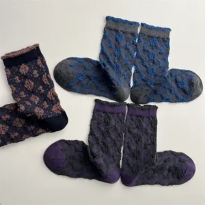 Detail shot of vintage floral textured mid-calf socks, cozy cotton knit with cute ruffles.