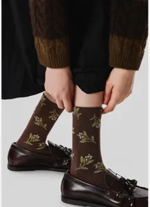 Detail shot of vintage floral mid-calf cotton socks in brown with green botanical embroidery.