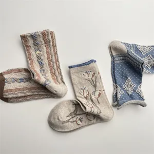 Close-up detail of autumn winter vintage floral and striped mid-calf cotton socks.
