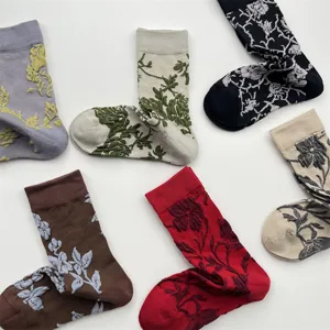 Vue détaillée de chaussettes mi-mollet à relief floral rétro, texture coton douce et plat arrangé.