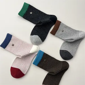 Close-up display details of Korean style color-blocking striped mid-calf socks with metal button.