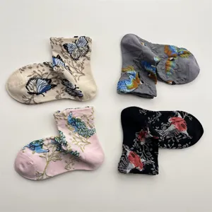 Close-up detail of vintage cotton mid-calf socks featuring 3D embroidered floral bird motifs.