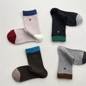 Close-up detail of stylish striped cotton mid-tube socks with contrast color and metal decor.